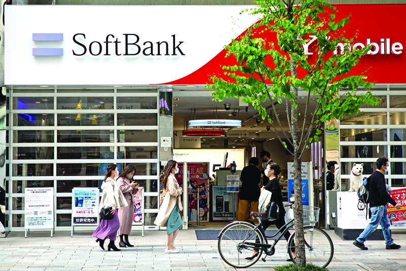 TOKYO: Pedestrians walk past a SoftBank mobile shop in the Ginza shopping district in Tokyo yesterday.-AFPn