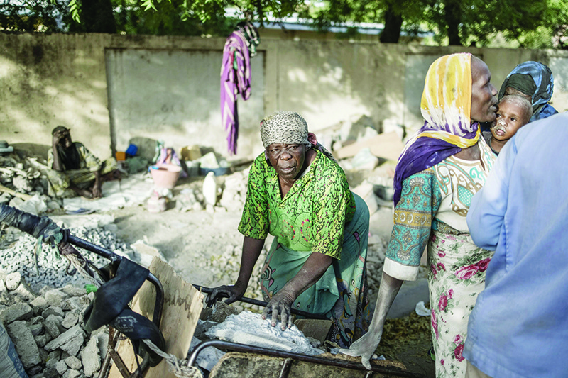 N’DJAMENA: Habiba, a gravel crusher who thinks she is between 50 and 60 years old, and Idjele, 38, choose slabs of stones from a cart near the Cite International des Affaires on April 12, 2021. — AFP
