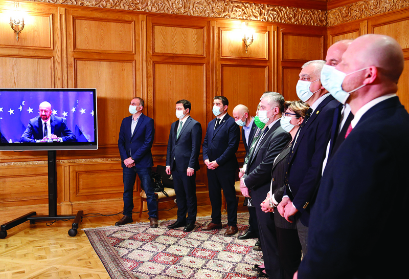 A handout photograph taken and released by Georgian Presidential Press Service Monday shows the European Council President Charles Michel on a screen as participants attend a meeting with Georgian President Salome Zurabishvili over the signature of a deal to end the current political crisis in Georgia. – AFPn