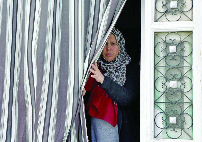 The sister of a 36-year-old Tunisian man identified as Jamel Gorchene, who stabbed to death a French police employee at her workplace southwest of the French capital Paris is pictured at the entrance of the family residence in the northeastern town of M'saken yesterday.-AFPn
