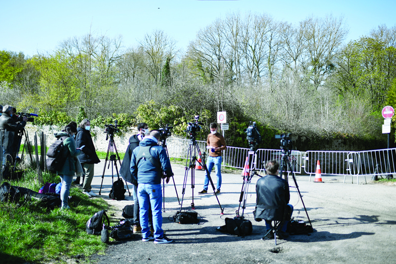 PARIS: Media and journalists stand outside the cordoned off area near the house of French businessman Bernard Tapie and his wife Dominique Tapie in Combs-la-Ville, southeastern suburbs of Paris yesterday.-AFPn