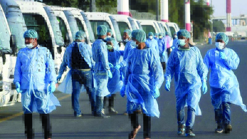 KUWAIT: In this file photo, Kuwait's Health Ministry workers, wearing protective outfits, wait on the tarmac of the Kuwait international Airport to receive Kuwaitis returning from Frankfurt on March 26, 2020. - Photo by Yasser Al-Zayyatn