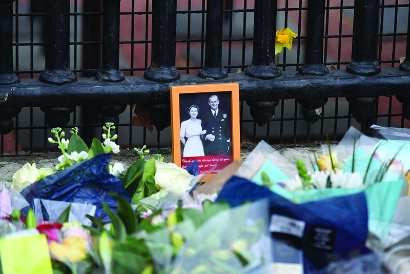 LONDON: A photograph of Britain's Queen Elizabeth II and Britain's Prince Philip, Duke of Edinburgh is seen, placed with floral tributes outside the gates of Buckingham Palace in central London.-AFPn