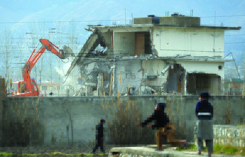 In this file photograph taken on February 26, 2012, Pakistani children play near demolition works on the compound where Al-Qaeda chief Osama bin Laden was slain in the northwestern town of Abbottabad. - AFPn