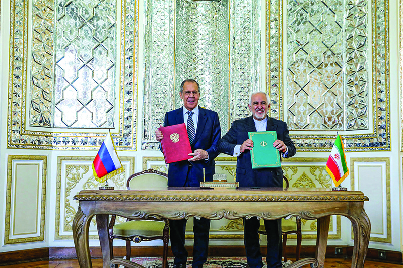 TEHRAN: Iranian Foreign Minister Mohammad Javad Zarif (center right) and Russia's Foreign Minister Sergei Lavrov (center left) posing for a photo with exchanged documents during their meeting at the ministry headquarters yesterday.-AFPn