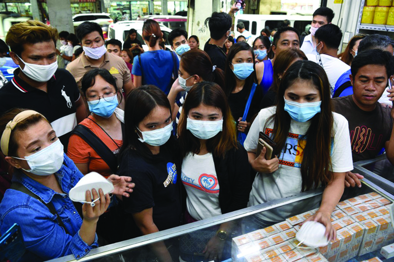 MANILA: In this January 31, 2020 file photo, people buy protective masks at a medical supplies store. - AFPn