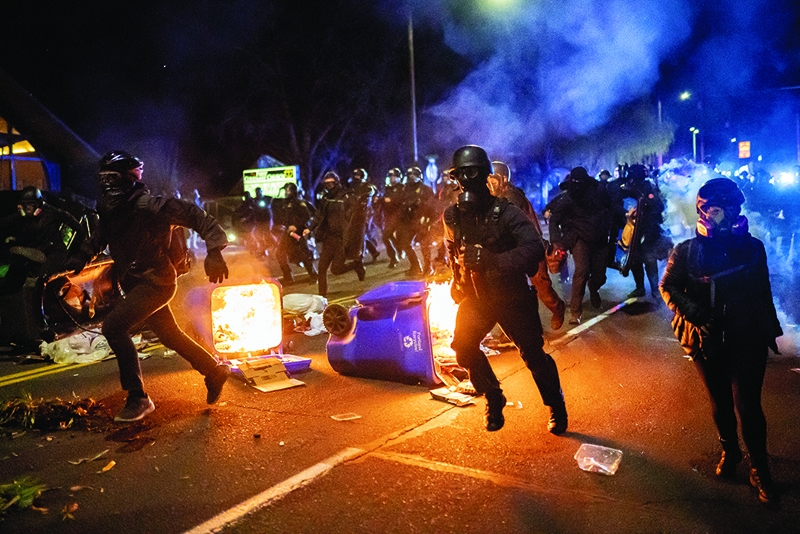PORTLAND, Oregon: Portland police officers chase demonstrators after a riot was declared during a protest against the killing of Daunte Wright Monday in Portland, Oregon. - AFPn