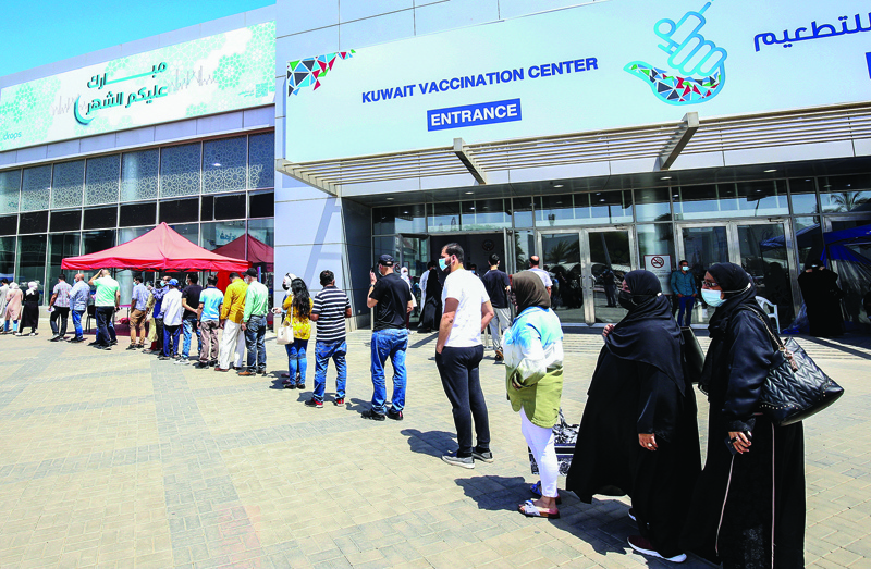 KUWAIT: People queue as they wait their turn to receive a dose of a vaccine against the coronavirus, in front of the makeshift Kuwait Vaccination Center at the Kuwait International Fairground in Mishref yesterday. - Photo by Yasser Al-Zayyatn