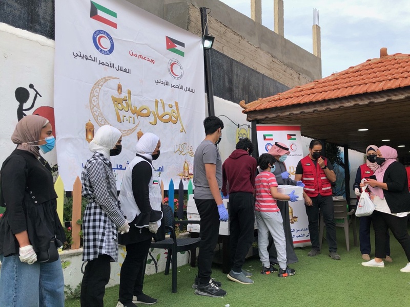 AMMAN: Kuwait Red Crescent Society workers distribute food as part of a project to offer free meals to 15,000 Syrian refugees in Jordan throughout Ramadan.- KUNAn