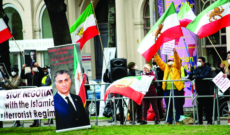 VIENNA: Members of the National Council of Resistance of Iran, an Iranian opposition group, stage a protest outside the 'Grand Hotel Wien' for the closed-door nuclear talks with Iran in Vienna yesterday where diplomats of the EU, China, Russia and Iran hold their talks. - AFPn