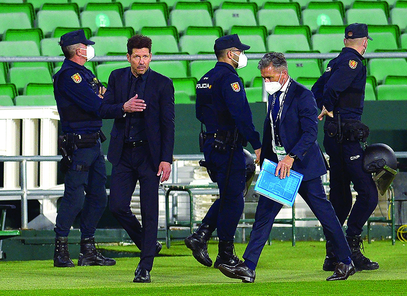 SEVILLE: Atletico Madrid’s Argentine coach Diego Simeone (2L) walks on the sideline during the Spanish League football match between Real Betis and Club Atletico de Madrid at the Benito Villamarin stadium in Seville on April 11, 2021. — AFP