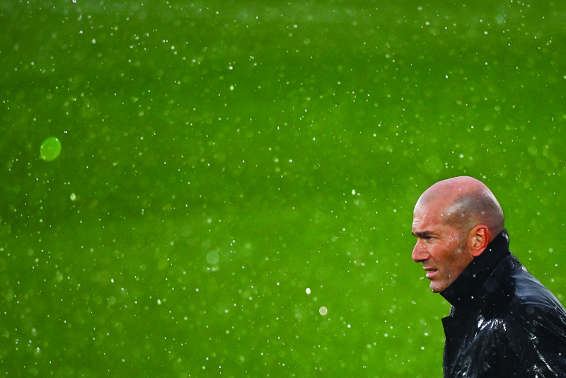 MADRID: Real Madrid's French coach Zinedine Zidane stands in the rain during the Spanish League football match between Real Madrid CF and SD Eibar at the Alfredo di Stefano stadium in Valdebebas on the outskirts of Madrid on April 3, 2021. - AFPn