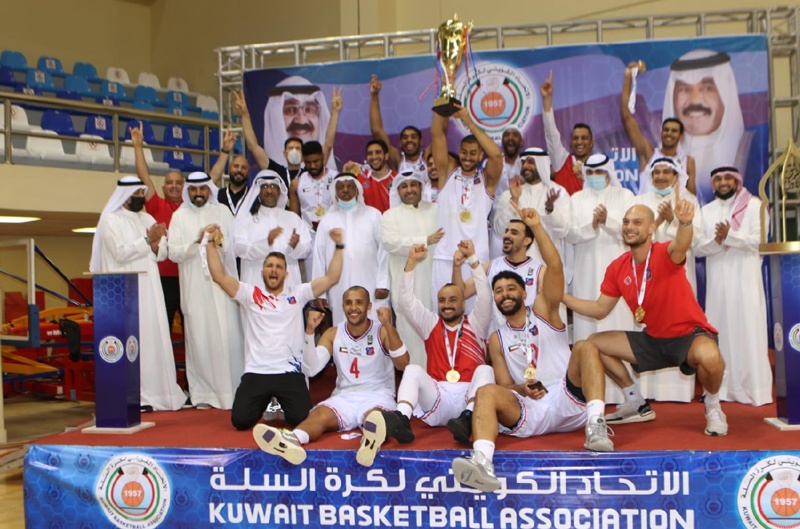 KUWAIT: Al-Kuwait players and staff celebrate with the championship's trophy. - KUNAn