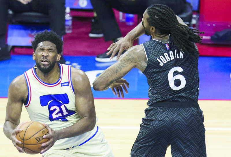PHILADELPHIA: DeAndre Jordan #6 of the Brooklyn Nets fouls Joel Embiid #21 of the Philadelphia 76ers in the third quarter at the Wells Fargo Center on Wednesday. - AFP n