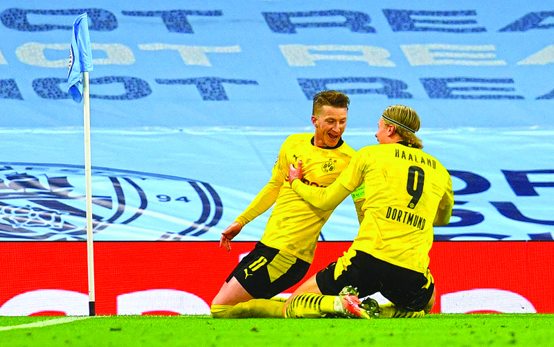 MANCHESTER: In this file photo taken on April 06, 2021 Dortmund's German forward Marco Reus (left) celebrates after scoring the equalizing goal with Dortmund's Norwegian forward Erling Braut Haaland during the UEFA Champions League first leg quarter-final football match between Manchester City and Borussia Dortmund at the Etihad Stadium in Manchester, north west England. – AFPn