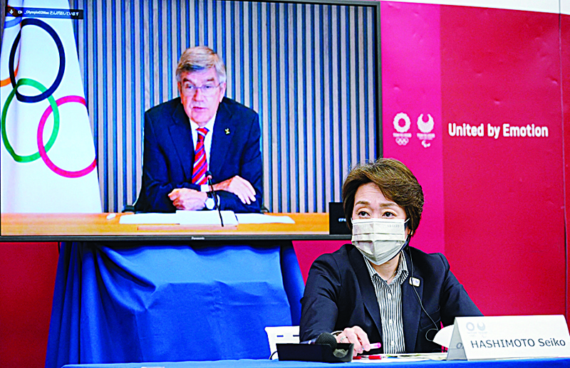 TOKYO: International Olympic Committee (IOC) president Thomas Bach (on screen) speaks as Tokyo 2020 Organizing Committee president Seiko Hashimoto listens during a five-party meeting of the Tokyo 2020 Olympic and Paralympic Games in Tokyo yesterday. - AFPn