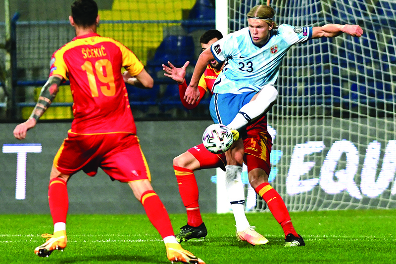 PODGORICA: Norway's Erling Haaland (right) fights for the ball with Montenegro's Aleksandar Scekic (left) and Igor Vujacic during the FIFA World Cup Qatar 2022 qualification Group G football match between Montenegro and Norway at the Podgorica City Stadium in Podgorica on March 30, 2021. - AFPnn