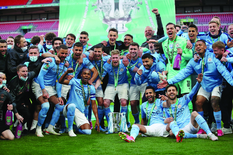 LONDON: Manchester City players celebrate with the trophy after winning the English League Cup final football match between Manchester City and Tottenham Hotspur at Wembley Stadium, northwest London on Sunday. - AFP n