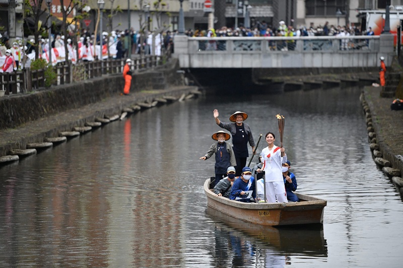TOCHIGI: This handout photograph taken and released on March 28, 2021 by Tokyo 2020 shows a Japanese torchbearer carrying the Olympic torch on a boat during the torch relay in the eastern city of Tochigi. - AFPn