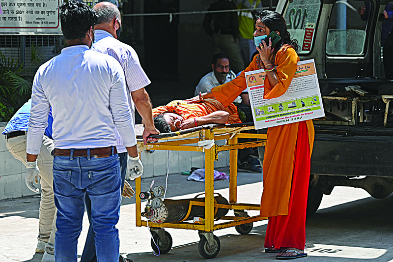 NEW DELHI: Relatives transport a Covid-19 coronavirus patient on a stretcher to a hospital in New Delhi yesterday.-AFPn