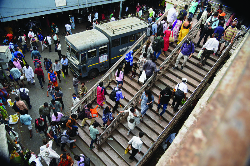 MUMBAI: People crowd at a railway station in Mumbai Monday. - AFPn