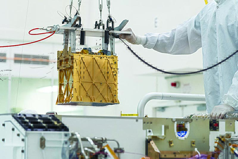Technicians in the clean room carefully lowering the Mars Oxygen In-Situ Resource Utilization Experiment (MOXIE) instrument into the belly of the Perseverance rover in the cleanroom at NASA's Jet Propulsion Laboratory, in Pasadena, California.-AFPn