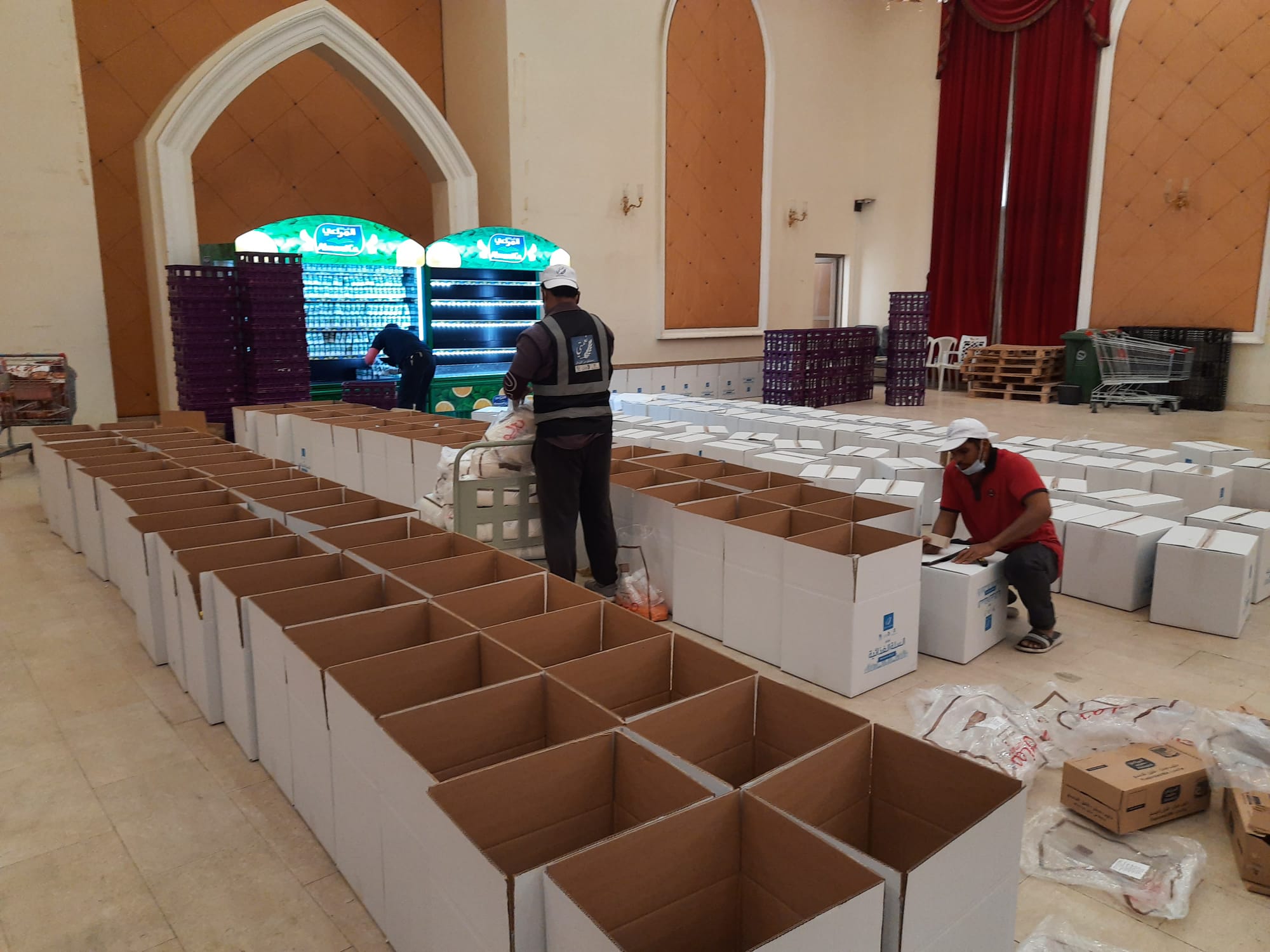 Volunteers stack foodstuff donated by companies at a repurposed marriage hall. 