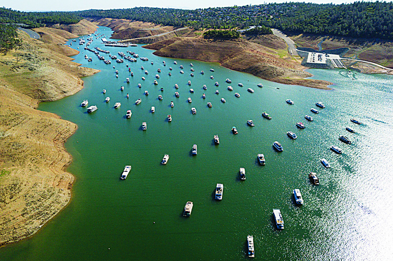 In this aerial image, houseboats are moored as dry land is exposed on the banks of Lake Oroville reservoir due to low water levels during the California drought emergency in Oroville, California. - AFPn