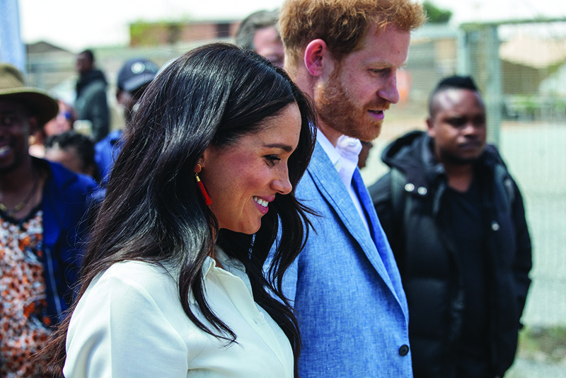 In this file photo Britain's Prince Harry, Duke of Sussex (right) and Meghan, Duchess of Sussex(left) leave the Youth Employment Services Hub in Tembisa township, Johannesburg.-AFP n