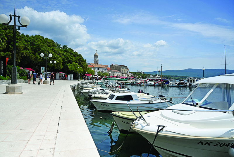 Tourists walk on the waterfront of the resort of Krk, on the northern island of Krk.n