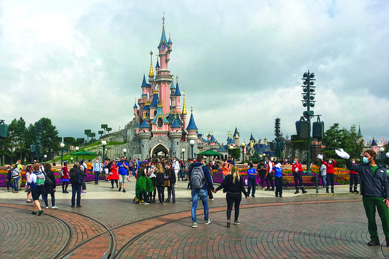 In this file photo visitors and staff wearing protective face masks, walk down the Main Street of Disneyland Paris in Marne-la-Vallee, near Paris.—AFP n