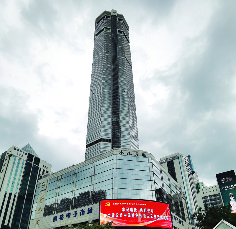 SHENZHEN: People stand outside the 300-metre high SEG Plaza (back center) after it began to shake, in Shenzhen in China's southern Guangdong province on Tuesday.-AFP n