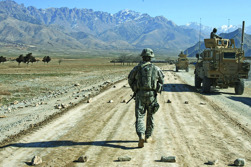 BAGRAM, AFGHANISTAN: In this file photo a US soldier of a team protection squad of a PRT (Provincial Reconstruction team) walks along a road under-construction near Bagram, about 60 kms from Kabul.—AFP n