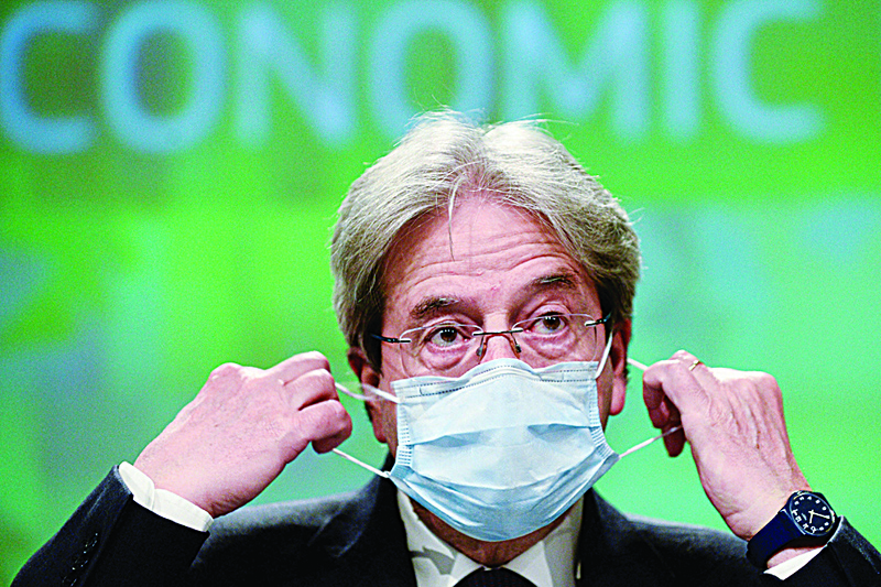BRUSSELS: European Commissioner for Economy Paolo Gentiloni takes off his mask upon his arrival to attend a news conference on the economic forecast for spring 2021 yesterday. - AFP n