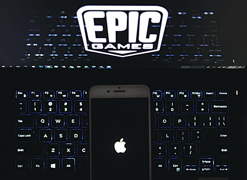 ARLINGTON, Virginia: This illustration picture shows the logo from Epic Games displayed on a laptop and an Apple logo on an iPhone on April 30, 2021. - AFP n