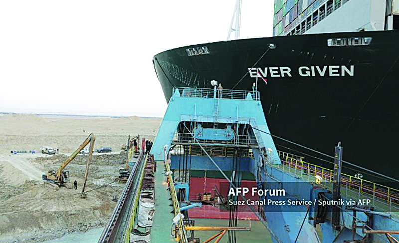 In this handout photo released by Suez Canal Press Service, an operation to re-float Ever Given container ship that ran aground in Suez Canal continues, in Egypt. - AFPn