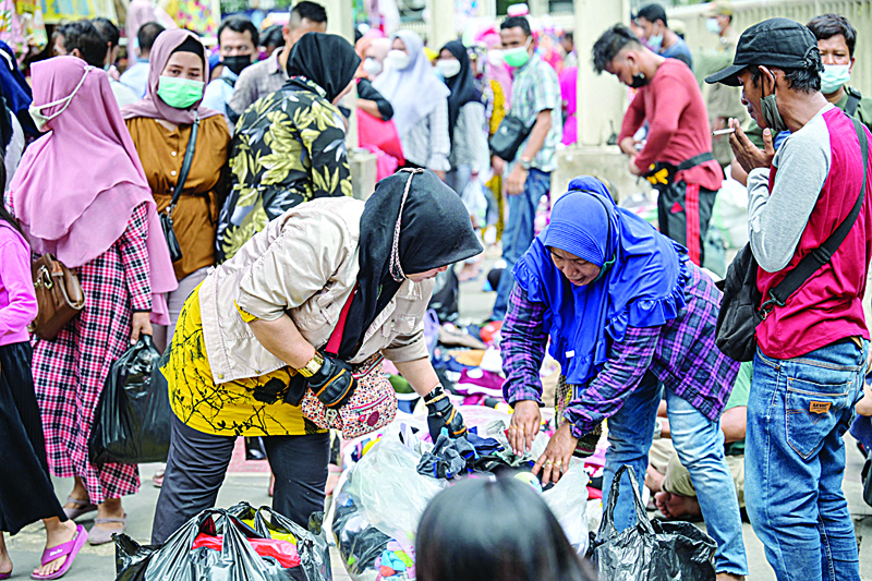 JAKARTA: People shop for clothes at street stalls in the Indonesian capital on Tuesday. - AFP n