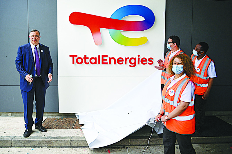 PARIS: Total Chief Executive Officer Patrick Pouyanne and Total employees remove a cover to reveal the new TotalEnergies logo during its unveiling ceremony in La Defense on Friday. – AFP nn