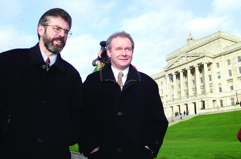 In this file photo taken on November 29, 1999 Sinn Fein's President Gerry Adams (left) and chief negotiator Martin McGuinness take a brief walk outside Stormont Parliament Buildings in Belfast. - AFPn
