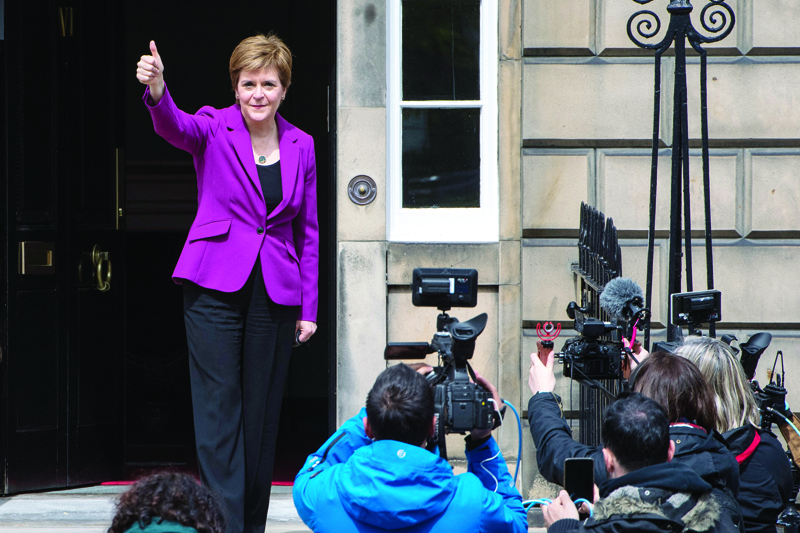 EDINBURGH: Scotland's First Minister and leader of the Scottish National Party (SNP), Nicola Sturgeon gives a thumbs-up on the steps of her official residence Bute House in Edinburgh yesterday following the party's landslide victory in the Scottish parliament elections. - AFPn