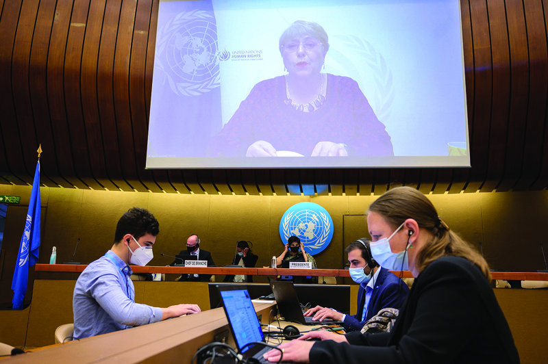 GENEVA: United Nations High Commissioner for Human Rights Michelle Bachelet is seen on a giant screen delivering her speech remotely at the opening of a UN Human Rights Council emergency meeting on occupied Palestinian territory and East Jerusalem, in Geneva yesterday.-AFP n