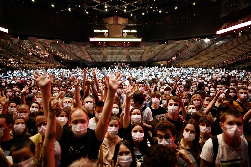 PARIS: People raise their hands before the start of a test concert of French rock band Indochine and French DJ Etienne de Crecy, aimed to investigate how such events can take place safely amidst the COVID-19 pandemic at the AccorHotels Arena yesterday. - AFP n