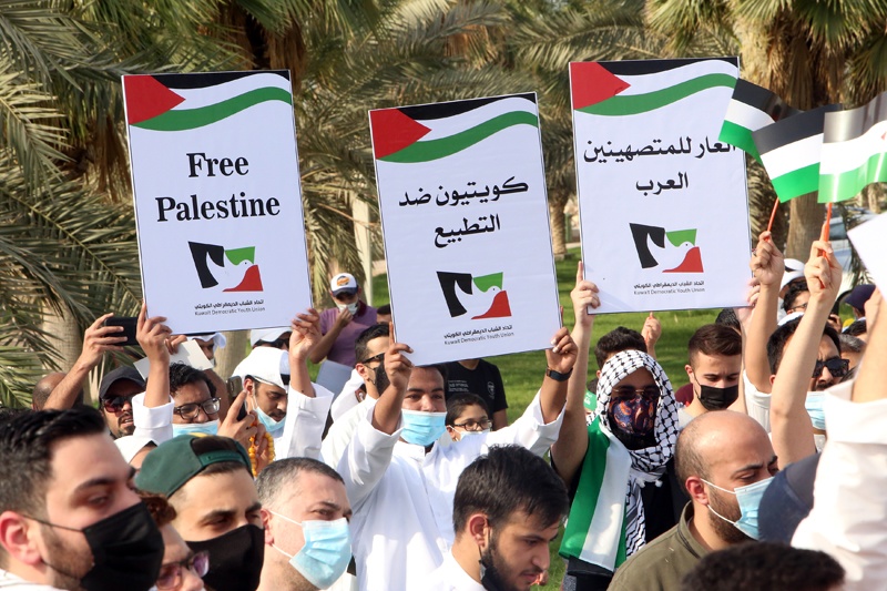 KUWAIT: People hold up placards during a protest in solidarity with the Palestinian people at the Iradah Square in Kuwait City yesterday. - Photo by Yasser Al-Zayyatnn