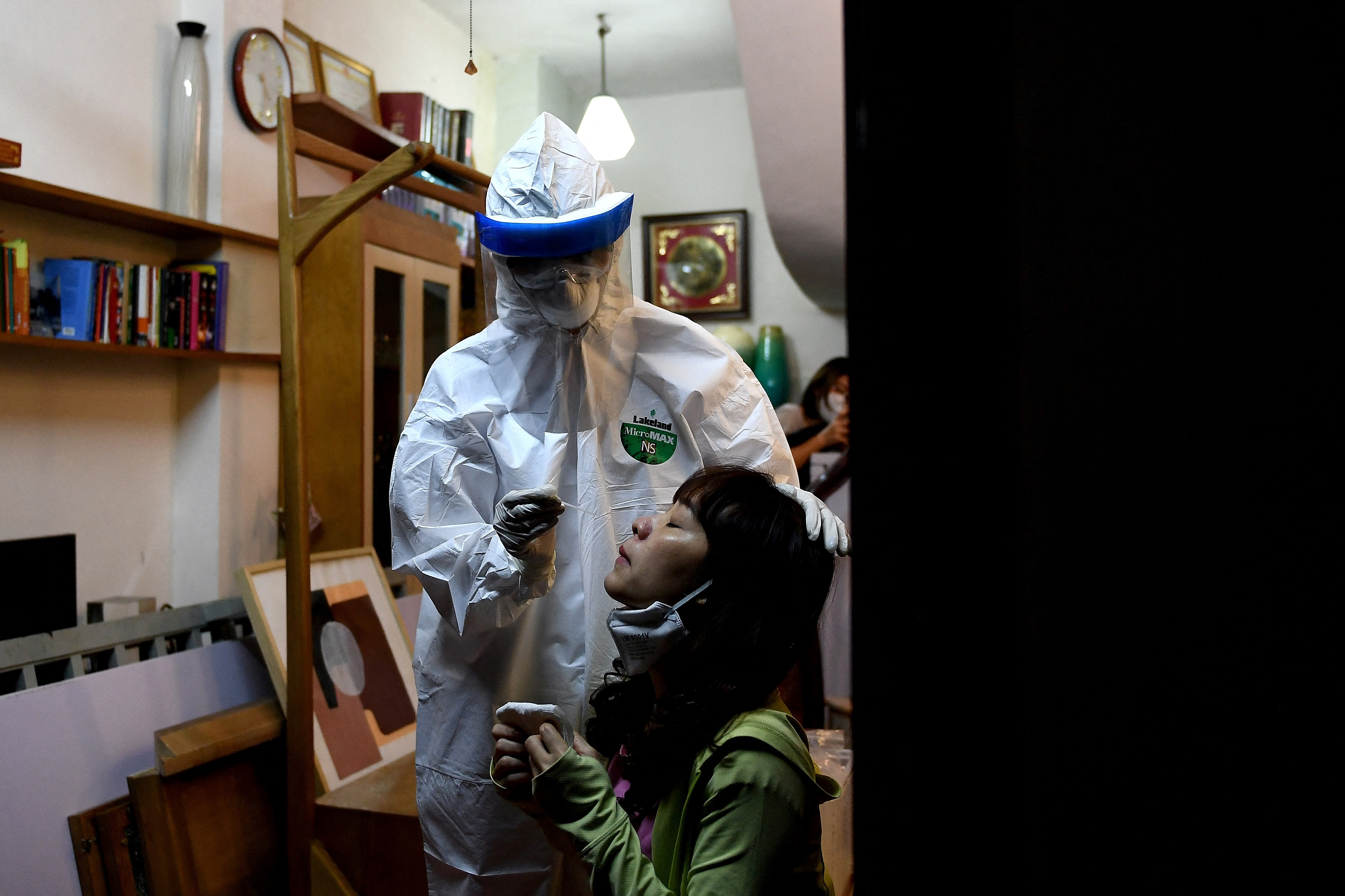 HANOI: In this file photo taken on March 30, 2020, a health worker conducts a swab test on a woman in her house. – AFP n