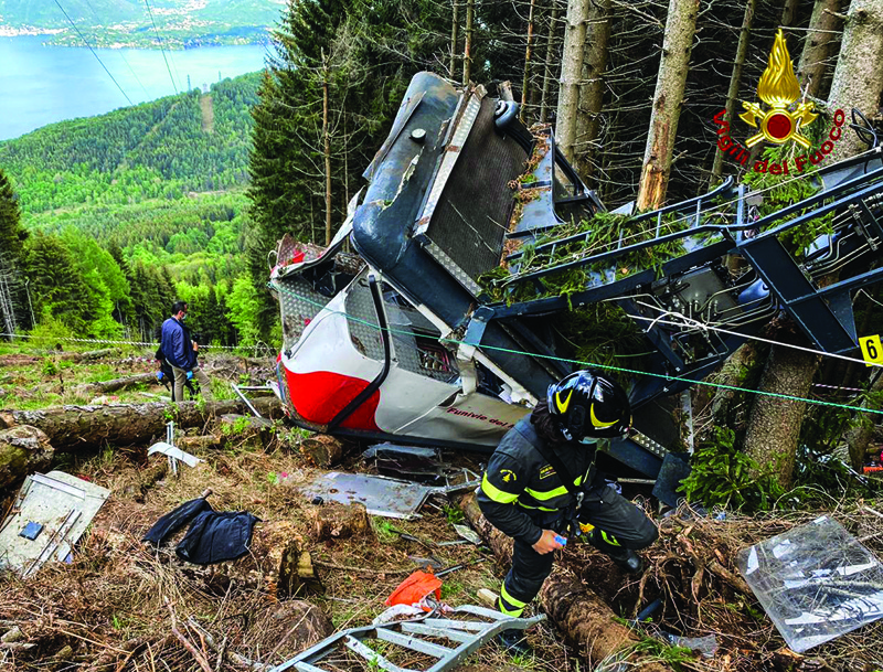 Rescuers are seen near a cable car that crashed to the ground in the resort town of Stresa on the shores of Lake Maggiore in the Piedmont region of Italy yesterday. - AFP n