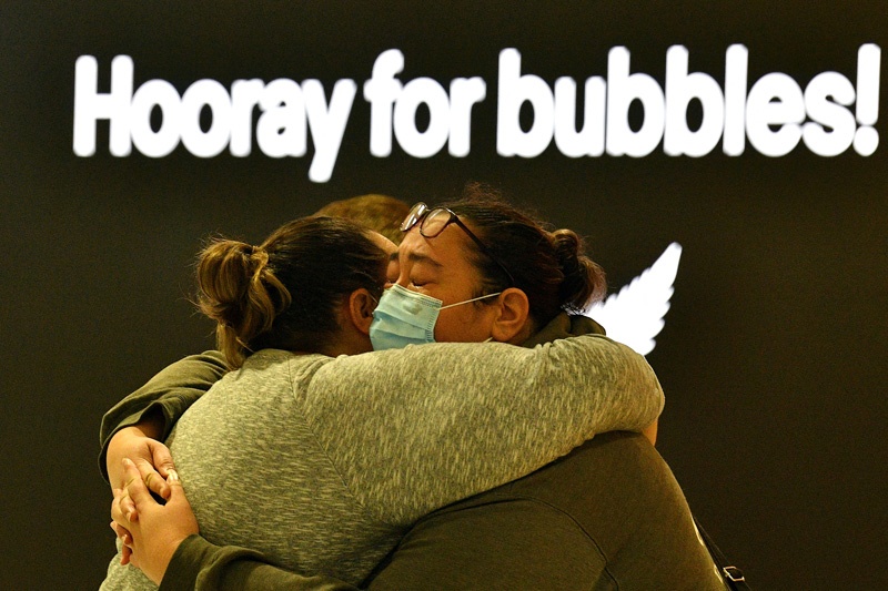 (FILES) In this file photo taken on April 19, 2021, a woman (R) hugs a family member before his departure for New Zealand at Sydney International Airport, as Australia and New Zealand opened a trans-Tasman quarantine-free travel bubble. - Quarantine-free travel bubbles were hailed as tourism's 'godsend' earlier this year, but coronavirus-enforced closures and suspensions have deflated hopes they will herald a return to pre-pandemic normality. (Photo by SAEED KHAN / AFP) / TO GO WITH AFP STORY NZEALAND-AUSTRALIA-TRAVEL-HEALTH-VIRUS,FOCUS BY NEIL SANDS