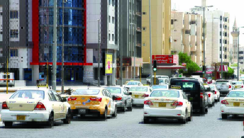 KUWAIT: Taxis stop at a traffic light in Salmiya in this file photo. - Photo by Fouad Al-Shaikhn