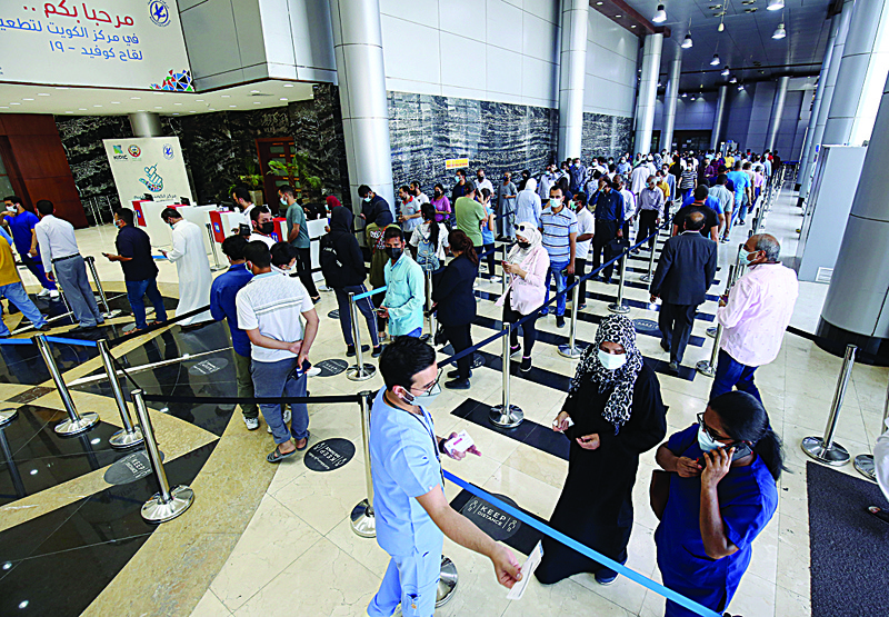KUWAIT: People wait in line to be vaccinated at Kuwait Vaccination Center in this file photo. - Photo by Yasser Al-Zayyatn