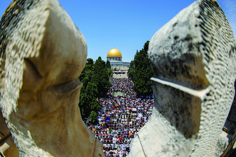 JERUSALEM: Palestinians gather to perform the last Friday prayers of the fasting month of Ramadan, outside the Dome of the Rock mosque at the Al-Aqsa mosque compound, Islam’s third holiest site, in Jerusalem's old city, Friday.—AFPn