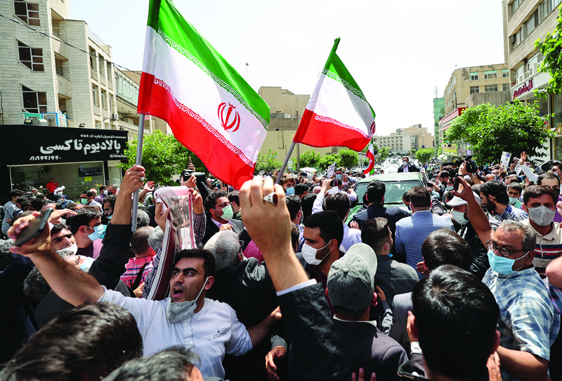 TEHRAN: Supporters of Iran's former president Mahmoud Ahmadinejad gather outside the Interior Ministry headquarters in the capital Tehran yesterday as Ahmadinejad arrives to register his candidacy to run again for president in the elections scheduled for June. – AFPnn